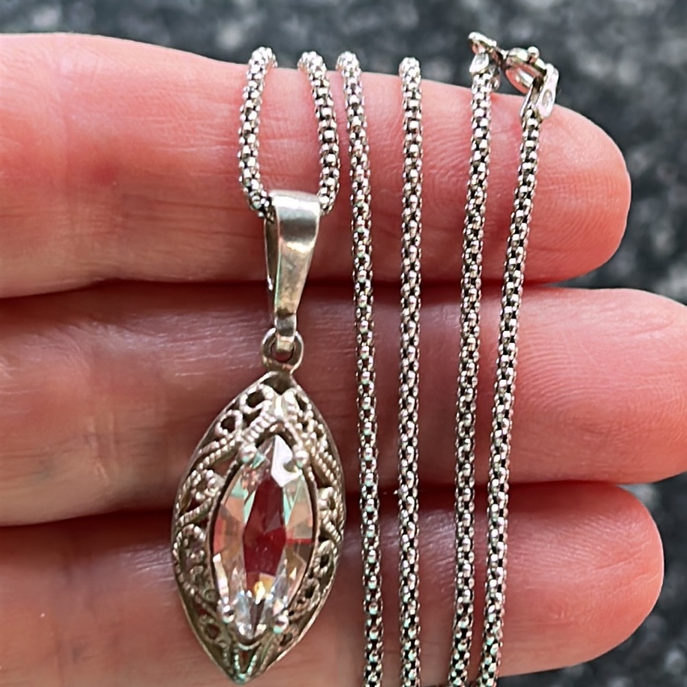 Silver necklace with oval pendant.
